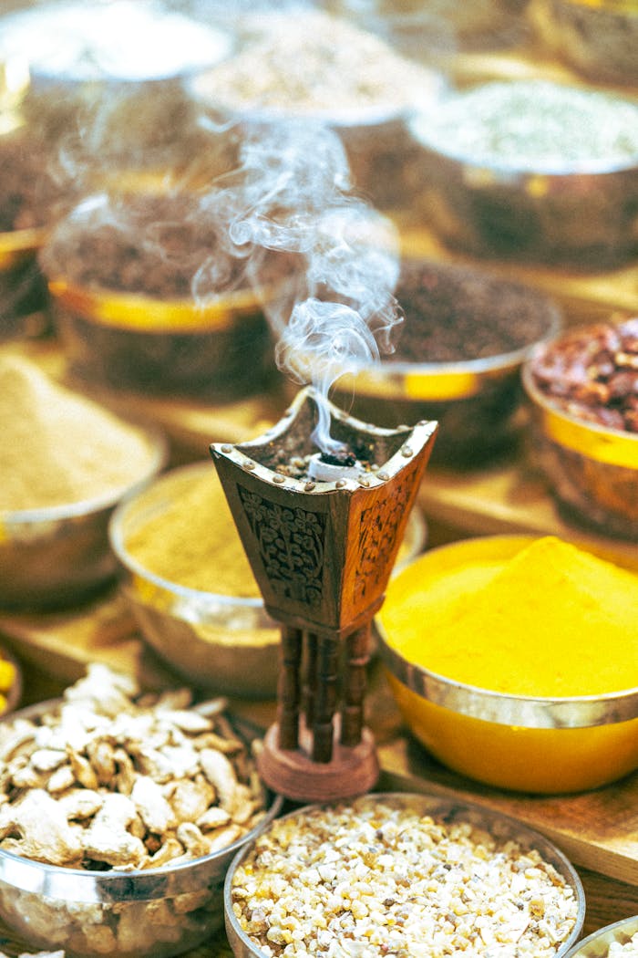 Colorful spices and incense burner with smoke in a traditional Dubai market setting.